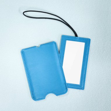 Sentetik arka planda mavi deri asılı etiket. Tasarımınız için boş ad etiketi.