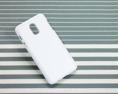 Çizgili arka planda cep telefonu kılıfı. Tasarımınız için telefon kılıfı yüzeyinin arka görünümü.