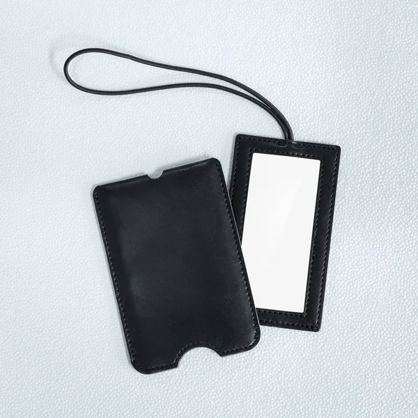 Sentetik arka planda siyah deri asılı etiket. Tasarımınız için boş ad etiketi.