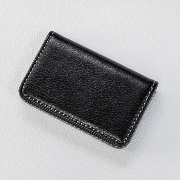 Sentetik beyaz arka plan üzerinde siyah deri kart tutucular. Paranızı saklamak için Deri cüzdan üst görünümü.