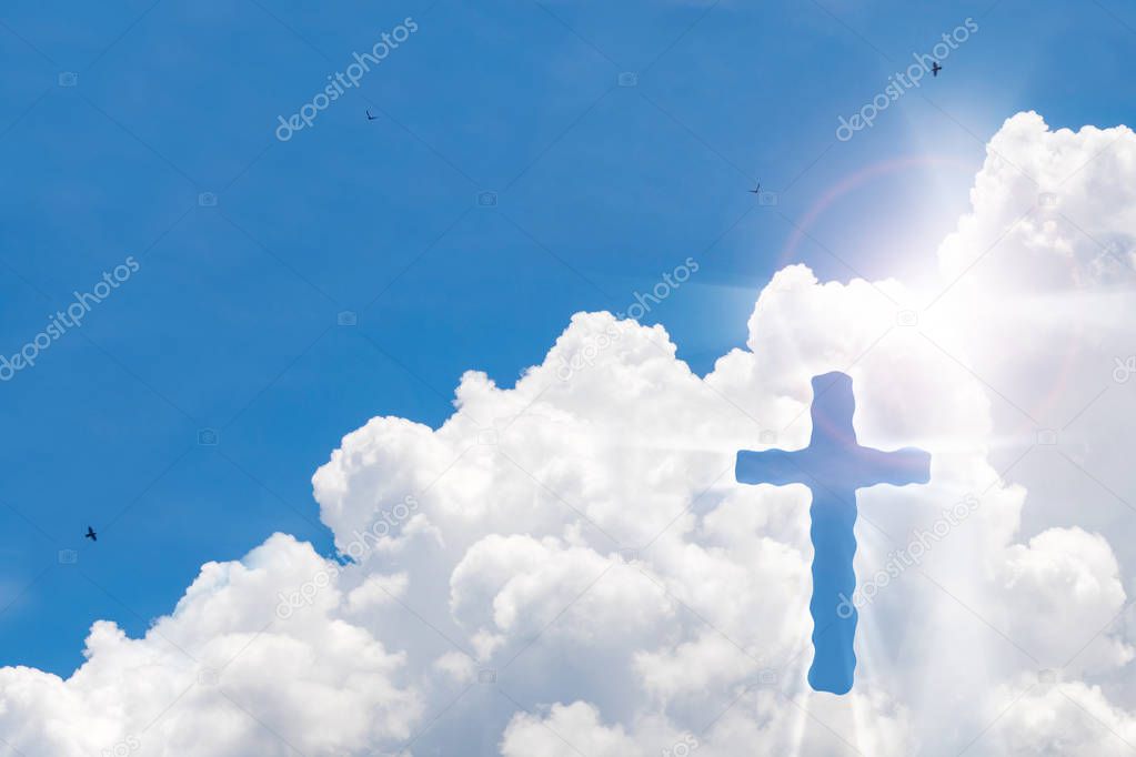 Crucifix cross on beautiful sky with sunbeam. Holy cross of Jesus christ on clouds background.