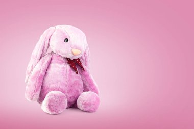 Tatlı arka planda büyük kulakları ile Pembe tavşan bebek. Çocuklar için sevimli doldurulmuş hayvan ve kabarık kürk.