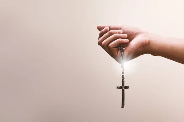 祈祷的手拿着一个十字架或金属项链的十字架 信仰宗教 信仰上帝在忏悔背景 爱和奉献的力量 免版税图库照片
