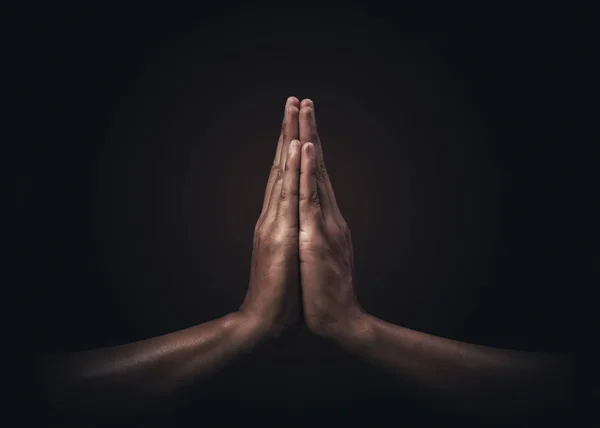 在黑暗的背景下对宗教和上帝的信仰进行祷告 爱和奉献的力量 Namaste或Namaskar的手势 祷告的立场 图库照片
