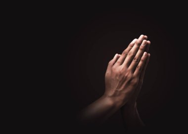 Karanlık arka planda dine ve Tanrı 'ya inançla dua eden eller. Umudun, sevginin ve bağlılığın gücü. Namaste veya Namaskar el hareketi. Dua pozisyonu.