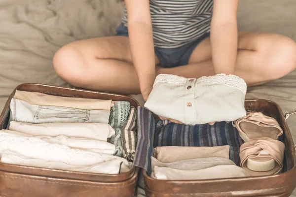 Glückliche Frau, die eine Reise plant und einen Koffer vorbereitet — Stockfoto