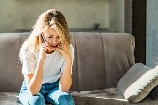 Genç bayan endişeli ve mutsuz bir şekilde giyinmiş. Cep telefonuyla konuşurken kötü haberler alıyor.