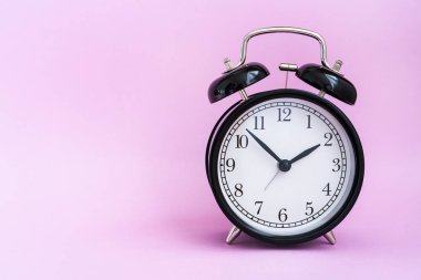 pembe arka plan üzerinde vintage siyah çalar saat