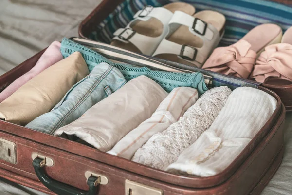 Giyim, aksesuar ve pasaport, seyahat ve tatil konsepti ile açık yolcu çantası
