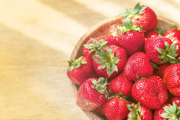 Ahşap kase üst görünümünde taze güzel çilek. Ahşap masa kopyalama alanı üzerinde çilek meyve.