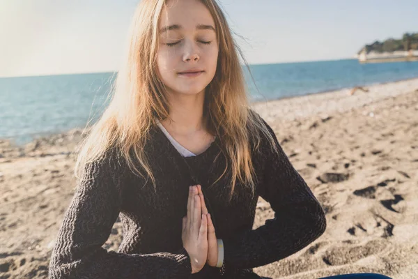 Glücklich entspannte junge Frau meditiert in Yoga-Pose am Strand — Stockfoto