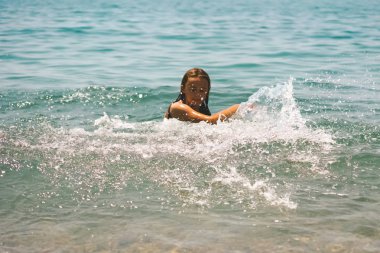 Yaz tatili - sevimli kız denizde sıçramaları yapar