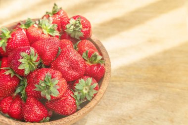 Ahşap kase üst görünümünde taze güzel çilek. Ahşap masa kopyalama alanı üzerinde çilek meyve.