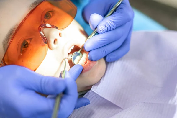Diş Kliniği. Resepsiyon, hastanın incelenmesi. Diş Bakımı. Genç kadın bir diş muayenesi bir diş hekimi tarafından geçer — Stok fotoğraf
