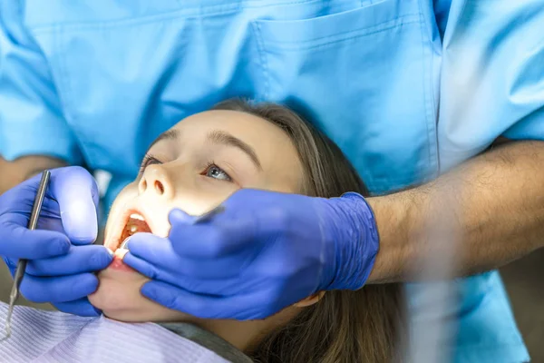 Οδοντιατρική κλινική. Υποδοχή, εξέταση του ασθενή. Φροντίδα των δοντιών. Νεαρή γυναίκα υποβάλλεται σε μια οδοντική εξέταση από τον οδοντίατρο — Φωτογραφία Αρχείου
