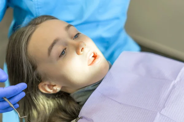 Clínica dentária. Recepção, exame do paciente. Cuidado com os dentes. Jovem é submetida a um exame odontológico por um dentista — Fotografia de Stock