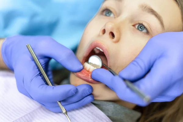 Clínica dentária. Recepção, exame do paciente. Cuidado com os dentes. Jovem é submetida a um exame odontológico por um dentista — Fotografia de Stock