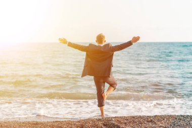 Mutlu işadamı plajda yoga yapıyor