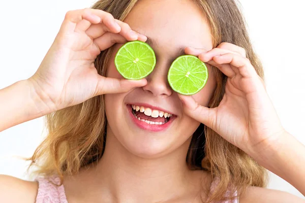 Cheerful funny comic positive girl having two pieces of lime, closing two eyes — Stock Photo, Image