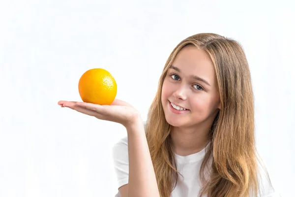 Girl with long hair in a white shirt holding orange — Stock Photo, Image