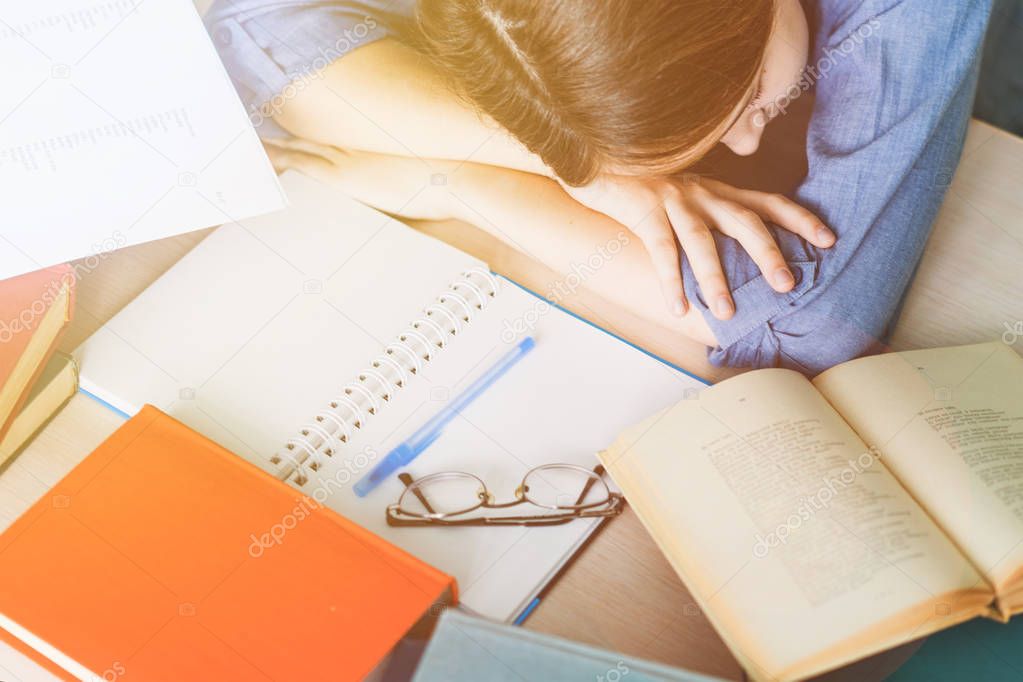 Stressed college student tired of hard learning with books in exams tests preparation