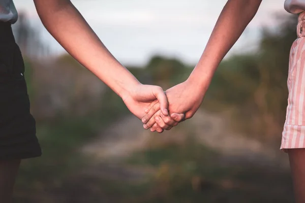 Twee meisje houden hand en wandelen op de weg. — Stockfoto