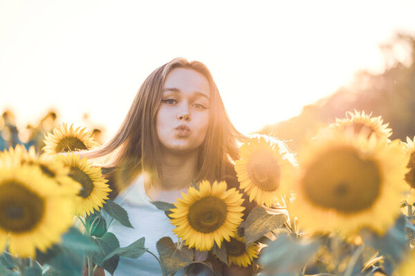 Young beautiful woman having fun in a sunflower field