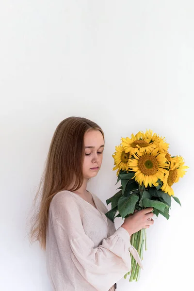 Vacker ung kvinna i linne klänning med solrosor bukett. — Stockfoto