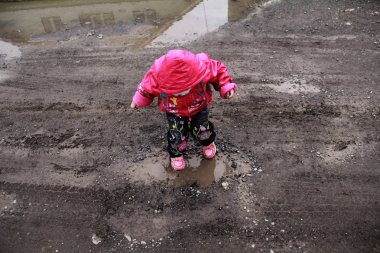 Kız bir su birikintisi atlama