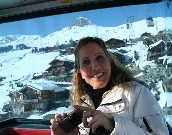 Dağlarda güneşli bir günde teleferik kar ayakta Gülümseyen kız. İsviçre, Verbier, Alpler