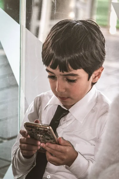Endülüs 'lü genç çocuk yeni teknolojileri portatif ekranında ne olduğuna dair çok kullanıyor. Moda tarzı, siyah saç ve kravat. İspanyol görünümü