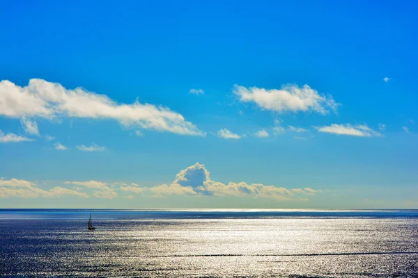 雲の中の夕日と空に対する海の孤独なヨット — ストック写真