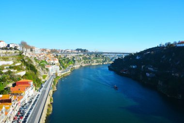Duoro Nehri 'nin kıvrımlarının manzarası. Bir motorlu gemi ve setlerin kıyısında duran evler.