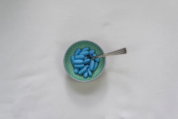 Petit bol avec des pilules bleues et cuillère — Photo