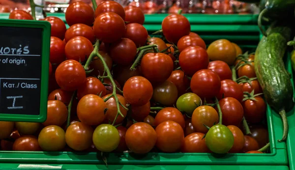 Cherry tomatoes in basket in supermarket, first-person view