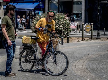 Sakallı ve bisikletli adam kameraya merakla bakıyor. 