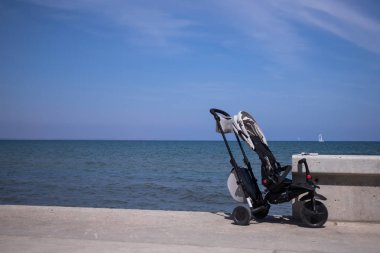 Deniz arka planlı Bebek Arabası