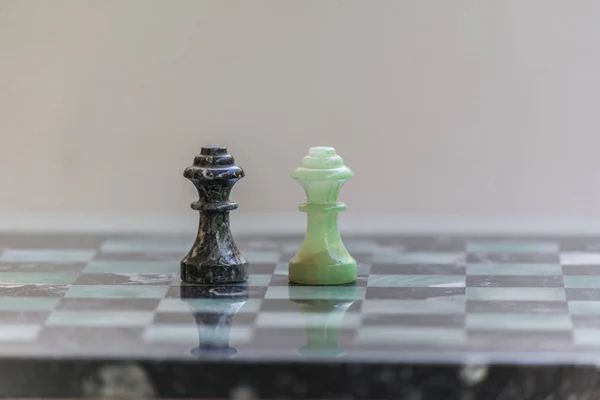 Peças de xadrez de mármore, em um tabuleiro de xadrez de mármore. Fechar. Imagem De Stock