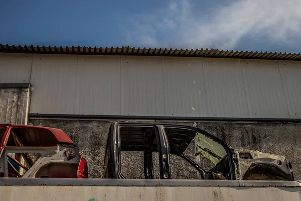 Skeletons of abandoned cars in junkyard