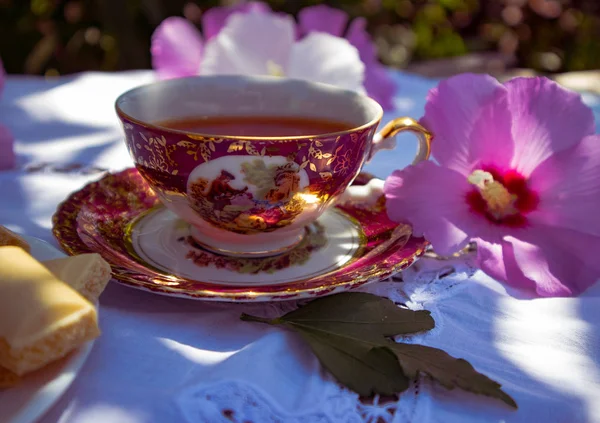 Vintage Cup Met Thee Wit Tafelkleed Paarse Bloemen Close — Stockfoto