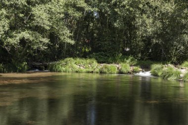 Küçük baraj taşlı Man tarafından inşa edilmiş ve yeşil bitki örtüsü ile çevrili küçük şelaleler görebilirsiniz kristal su ile beslenen.
