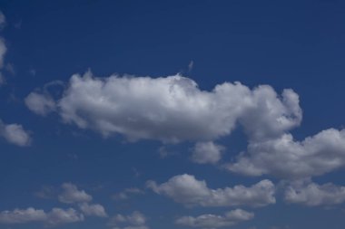 Arka planda güzel mavi gökyüzü olan beyaz bulutlar.