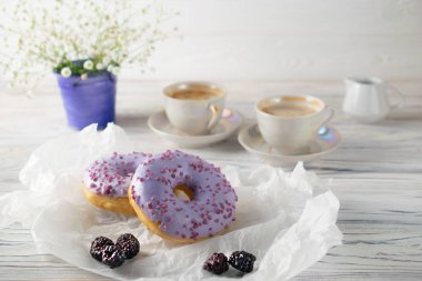 Taze kahve ve krema ile böğürtlen donut pişirir, sabah kahvaltı ayarı