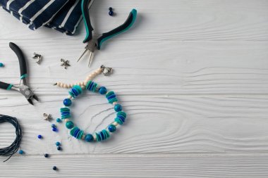 El yapımı turqouise bilezik, pare, boncuk ve araçları ile tepeyle düz yatıyordu kompozisyon