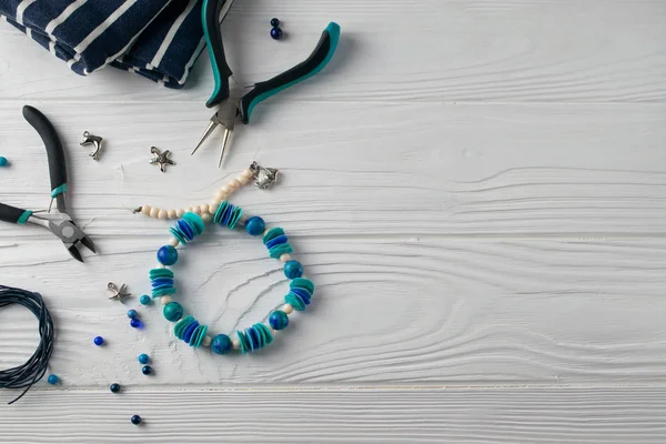 El yapımı turqouise bilezik, pare, boncuk ve araçları ile tepeyle düz yatıyordu kompozisyon