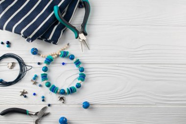 El yapımı turqouise bilezik, pare, boncuk ve araçları ile tepeyle düz yatıyordu kompozisyon