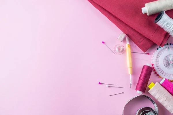 Colorful sewing threads on a pink background, overhead flat lay — Stock Photo, Image