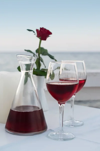 Romantic evening drinking red wine in restaurant by the sea
