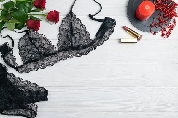 Black lace elegant lingerie composition with red roses and candle — Stock Photo, Image