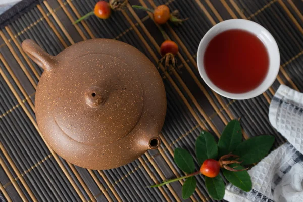 Health natural rose hip tea with honey on a table with teapot